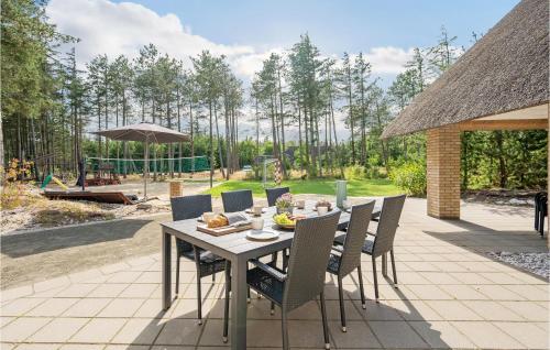 a dining table and chairs on a patio at Lovely Home In Ulfborg With Sauna in Øhuse