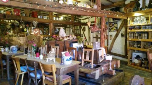ein Zimmer mit Tischen und Stühlen in einem Laden in der Unterkunft Historische Wassermühle in Birgel