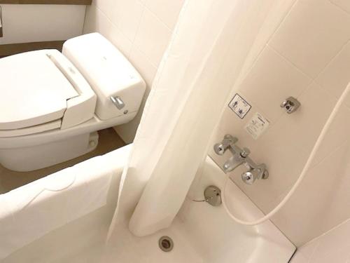 a white bathroom with a toilet and a shower at Green Rich Hotel Aso Kumamoto Airport (Artificial hot spring Futamata Yunohana) in Kikuchi