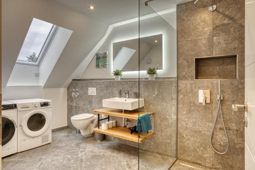 a bathroom with a sink and a washing machine at Uii Apartments Oberaudorf in Oberaudorf