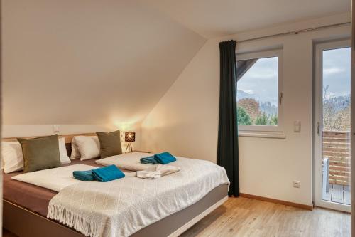a bedroom with a bed with blue pillows and a window at Uii Apartments Oberaudorf in Oberaudorf