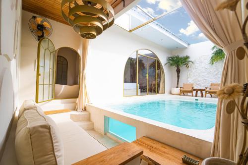 a large indoor swimming pool with a large glass ceiling at La Dorada by Bohemian Jogja Villas in Jetis