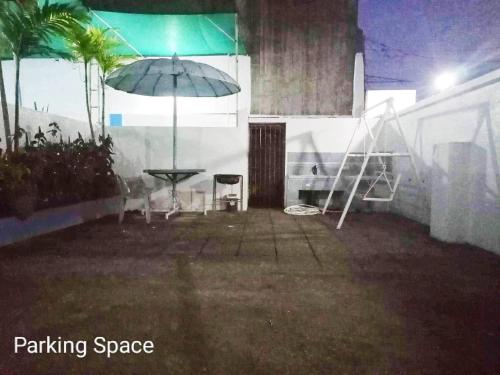 a patio with a table and an umbrella at Amor de Hermanas in Calamba