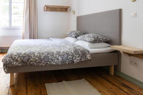 a bedroom with a bed with a gray headboard and pillows at Apartamenti Strand in Saulkrasti
