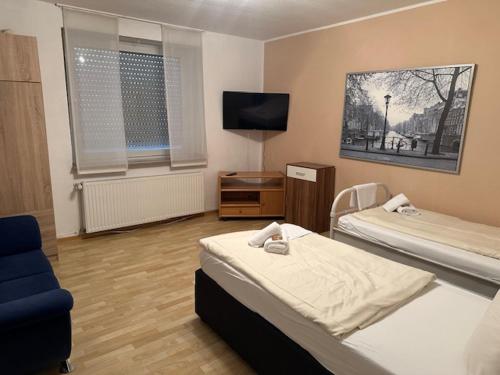 Una habitación de hotel con dos camas y un televisor. en Luca´s Apartments, en Warendorf