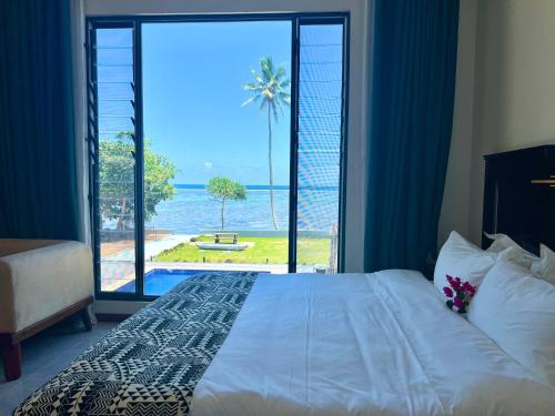 a bedroom with a bed and a view of the ocean at coral coast FIJI in Sigatoka