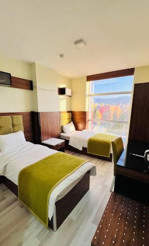 a hotel room with two beds and a window at GRAND AĞA HOTEL in Doğubayazıt