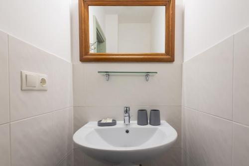 a bathroom with a white sink and a mirror at Apartamenti Strand in Saulkrasti