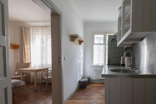 a small kitchen with a sink and a table at Apartamenti Strand in Saulkrasti