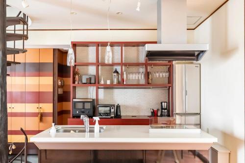 a kitchen with a sink and a refrigerator at ハンドインハンド岡山後楽園まで徒歩約5分 in Okayama