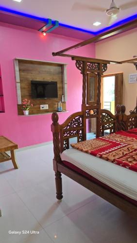 a bedroom with a bed in a room with pink walls at Abhi Homestay Hampi in Hampi