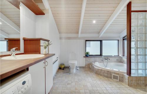 a bathroom with a tub and a toilet and a sink at Holiday Home Knold-Åsen H-617 in Vejby