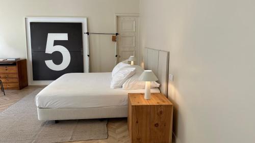 a bedroom with a bed and a table with a number five at Downtown collection apartments in Funchal
