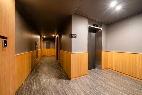 a corridor of an office with wooden walls and doors at Jamsil Stay 509 in Seoul
