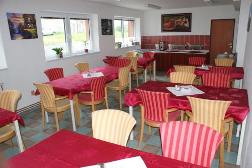 un restaurante con mesas rojas y sillas en una habitación en Apartmá Lipno, en Horní Planá