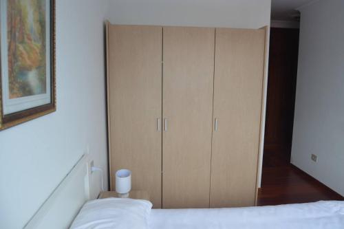 a bedroom with a bed and a cabinet at Precioso apartamento de 3 habitaciones en Cabañas in Cabañas