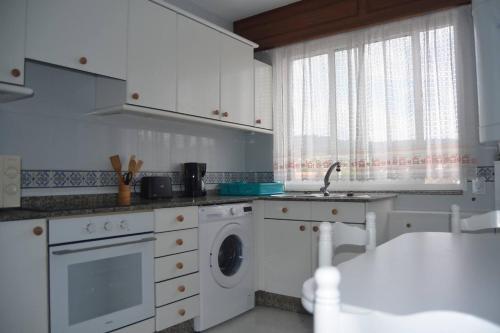 a kitchen with a washing machine and a sink at Precioso apartamento de 3 habitaciones en Cabañas in Cabañas