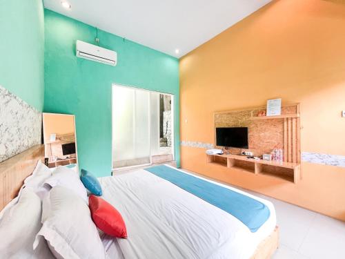 a bedroom with a large bed and a large window at Sans Borobudur Homestay Banyuwangi in Banyuwangi