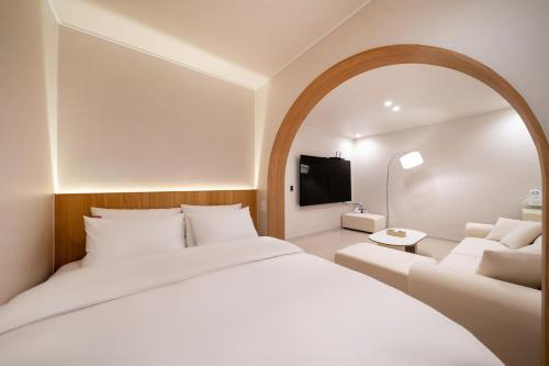 a bedroom with a large white bed and a couch at Jamsil Stay 509 in Seoul