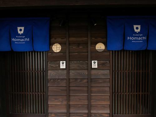a room with wooden doors and signs on the wall at Auberge Homachi Mikuniminato in Sakai