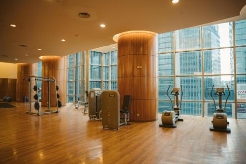 a gym with cardio equipment in a building with large windows at St Giles Gardens Residences Kuala Lumpur in Kuala Lumpur
