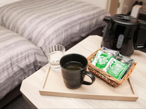 a tray with a coffee maker and a glass of water at Hotel Route-Inn Yamagata Ekimae in Yamagata
