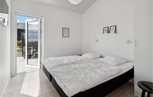 a bed in a white room with a window at Three-Bedroom Holiday Home In Haderslev in Haderslev