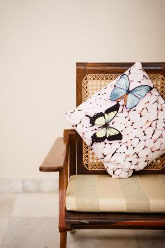 a chair with a pillow with butterflies on it at Girisadan Boutique Stay in Jaipur