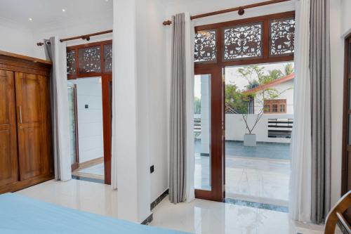 a bedroom with doors open to a patio at Amith Villa in Aluthgama