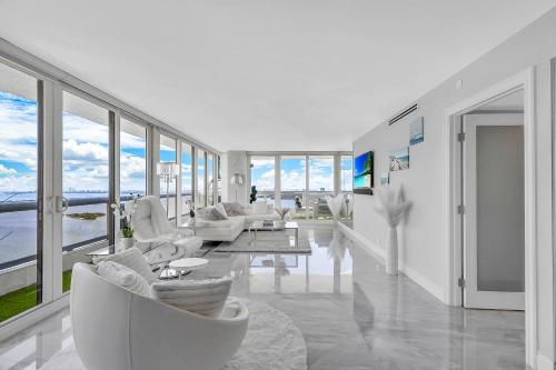 a living room with white furniture and large windows at The Grand Biscayne Bay in Miami