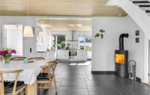 eine Küche mit einem Esstisch und einem Kamin in der Unterkunft Four-Bedroom Holiday Home In Borkop in Børkop