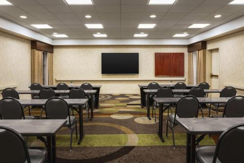 a conference room with tables and chairs and a screen at Hampton Inn Tropicana in Las Vegas