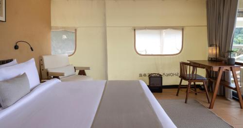 a bedroom with a bed and a desk and a table at Zen By Stellar Cameron in Brinchang