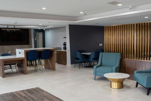 a waiting room with blue chairs and a table at La Quinta by Wyndham Dallas Mesquite in Mesquite