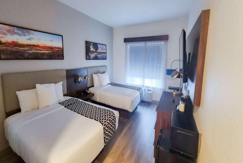 a hotel room with two beds and a television at La Quinta by Wyndham Dallas Mesquite in Mesquite