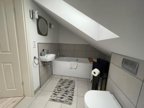 a bathroom with a sink and a tub and a toilet at Ferienwohnung Trupermoor in Lilienthal
