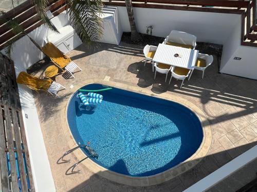 an overhead view of a swimming pool with chairs and a table at Amour Et Citrons in Protaras
