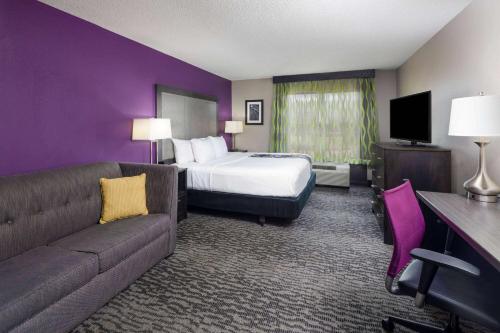 a hotel room with a bed and a couch at La Quinta by Wyndham Kennesaw in Kennesaw