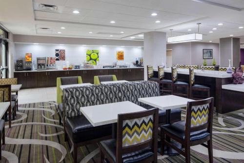 a restaurant with tables and chairs and a counter at La Quinta by Wyndham Kennesaw in Kennesaw