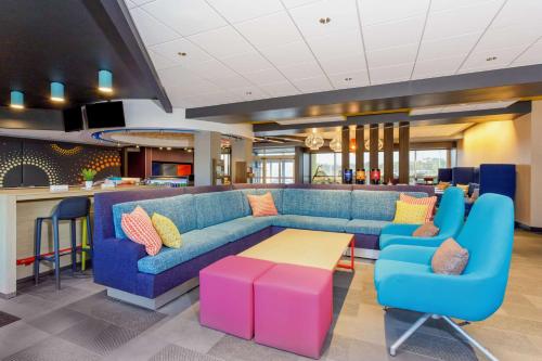 a living room with a blue couch and a table at Tru By Hilton Panama City Beach in Panama City Beach
