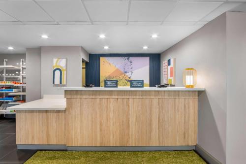 an office lobby with a reception counter and artwork at Spark by Hilton Richardson Dallas in Richardson