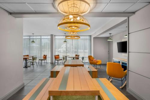 a conference room with tables and chairs and a television at Spark by Hilton Richardson Dallas in Richardson