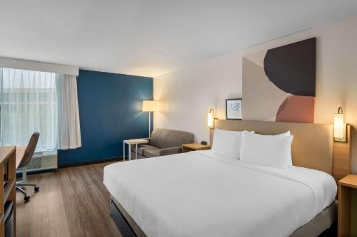 a hotel room with a large bed and a chair at Spark by Hilton Richardson Dallas in Richardson