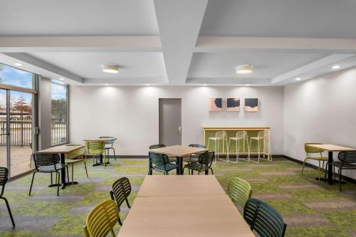 a room with tables and chairs and windows at Spark by Hilton Richardson Dallas in Richardson