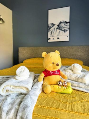 a teddy bear sitting on a bed with towels at Modern & Spacious Family and Friend 4B3B House in Moreno Valley