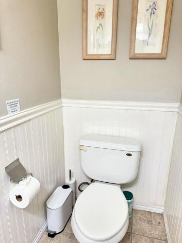 a bathroom with a toilet and two pictures on the wall at Modern & Spacious Family and Friend 4B3B House in Moreno Valley