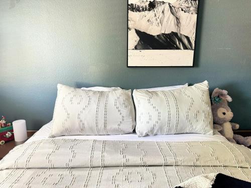 a bed with white sheets and a picture on the wall at Modern & Spacious Family and Friend 4B3B House in Moreno Valley