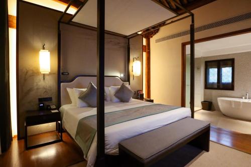 YuyaoにあるYuyao Yangmingguan Hotelのベッドルーム1室(ベッド1台、バスタブ付)、ベッドルーム1室(ベッド1台付)