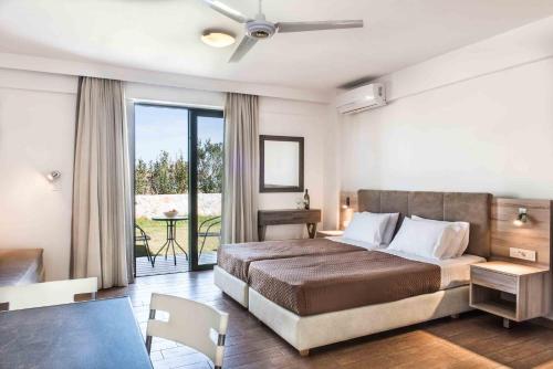 a bedroom with a large bed and a balcony at Gerona Mare Apartments in Gerani Chanion