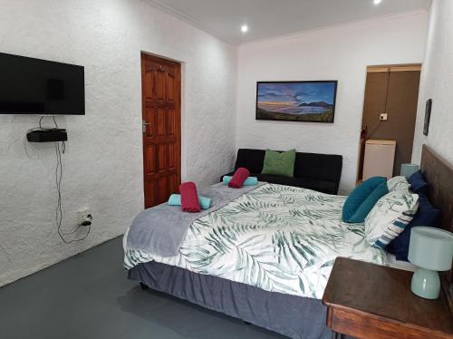 a bedroom with a bed and a flat screen tv at Faodail Guest House in Velddrif